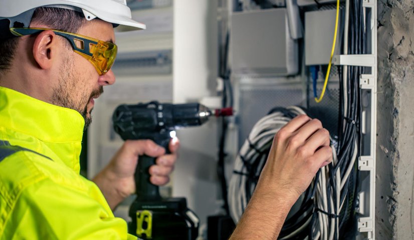 Technician on-site performing hardware repair and cable tracing in a server room